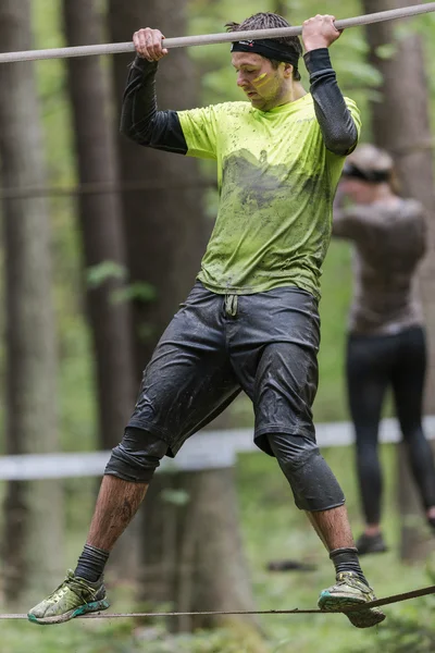 Sideview ofman on slack line at Tough Viking obstacle course aro