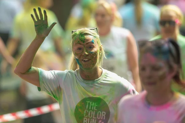 Female runner waving between the color stations at Color Run Tro