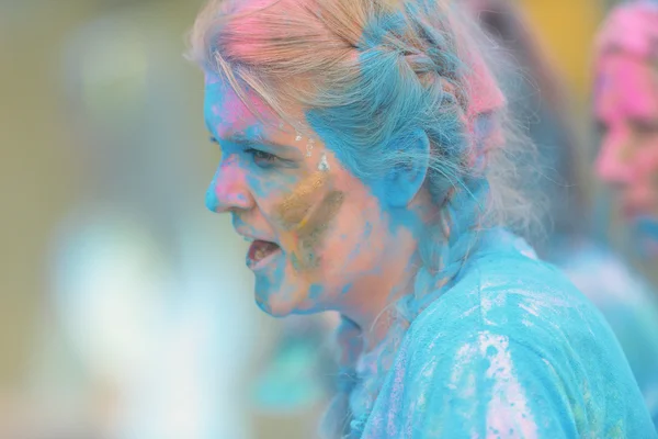 Sideview of female runner at the last blue station at Color Run