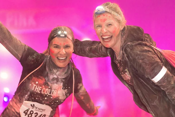 Two colorful happy friends posing at the Color Run Night Edition