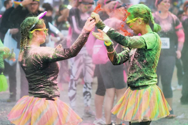 Friends throwing color at each other at the Color Run Night Edit
