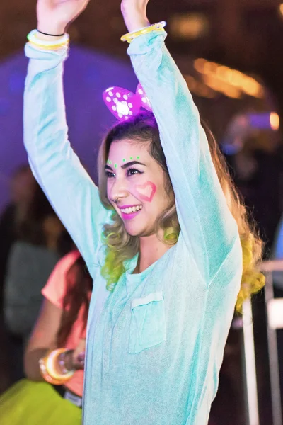 Colorful happy woman at the Color Run Night Edition in Stockholm