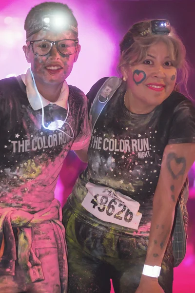 Colorful happy mother and son at the Color Run Night Edition in