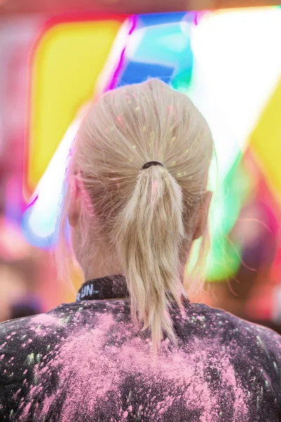 Back of a girls colorful head at the Color Run Night Edition in