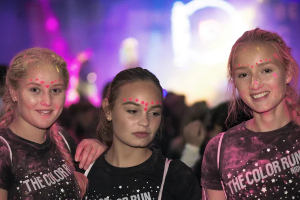 Colorful happy friends posing at the Color Run Night Edition in