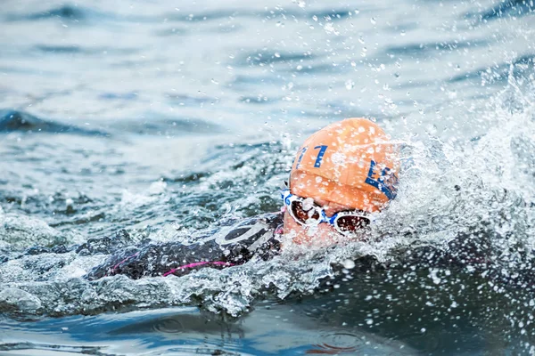 Closeup of a triathlete swimming in the cold water at the Womans