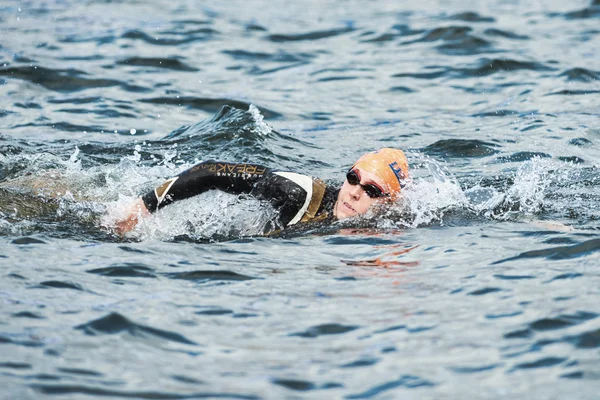 Closeup of a triathlete swimming in the cold water at the Womans