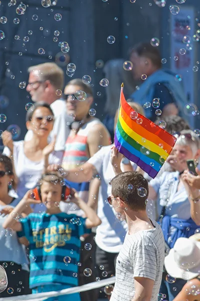 Man with rainbow flag and bubbles during the Pride parade