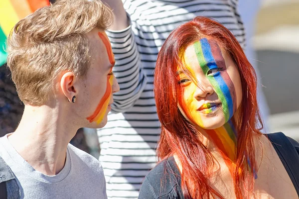 Asian girl with red hair and and a white guy with face in rainbo