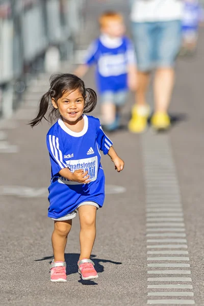 Young happy girl with big blue shirt running the Minimil for the