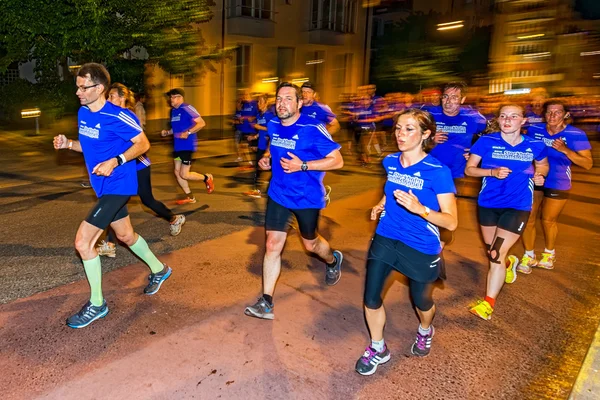 Group of runners in vivid colors on the streets of Soder at Midn