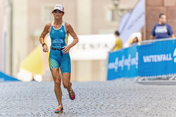 Woman triathlete running at the cobblestones in the old town at