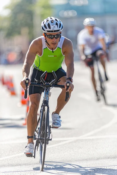 Male triathlete on a bike in a curve at the old town in the ITU