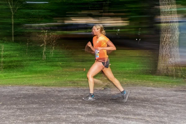 Female runner in motion blur in forest at the event 5K EASD Run