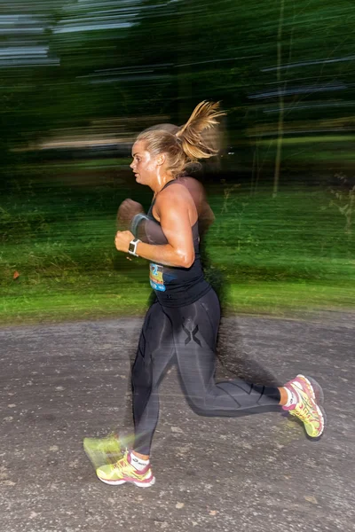 Female runner in motion blur in forest at the event 5K EASD Run