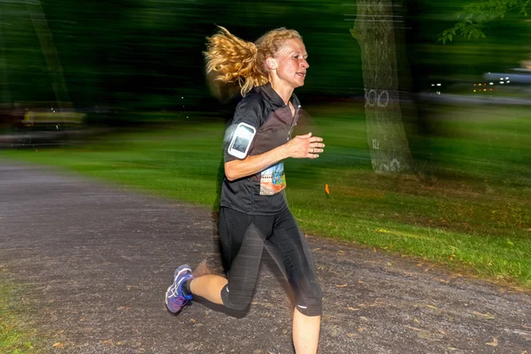 Female runner with motion blur in forest at the event 5K EASD Ru