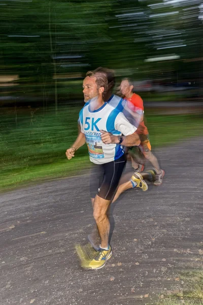 Male runner in motion blur in forest at the event 5K EASD Run Wa