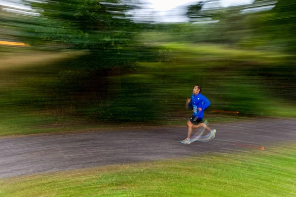 Runner in motion blur in forest at the event 5K EASD Run Walk to
