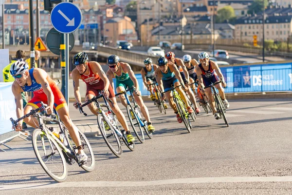 Group of male triathletes on bicycles in a curve at the Men\'s IT