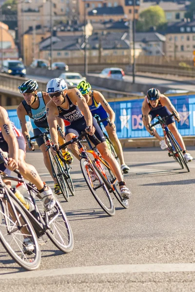 Group of male triathletes on bicycles in a curve at the Men's IT