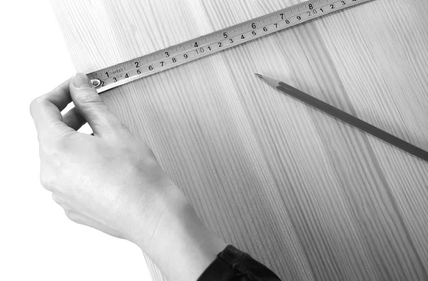 Using a steel tape measure on a wooden board