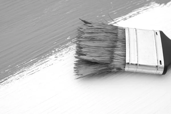 Close-up of paintbrush painting a board