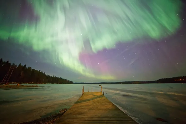 Northern lights and  green aurora corona in the cold winter sky.