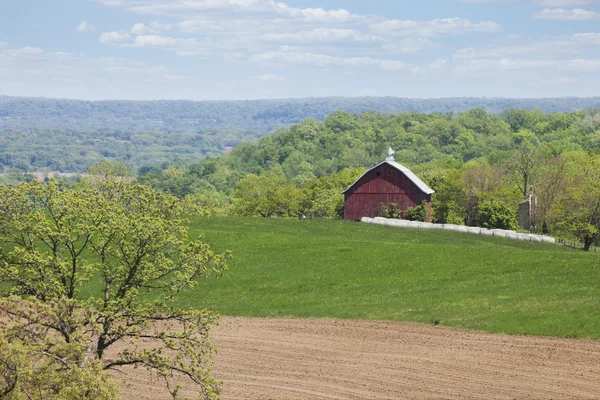 Old red barn, trees and fields in the Iowa countryside