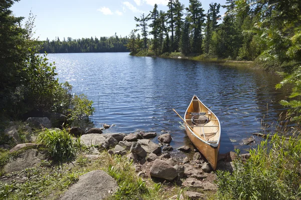 A fisherman\'s canoe on rocky shore in northern Minnesota lake