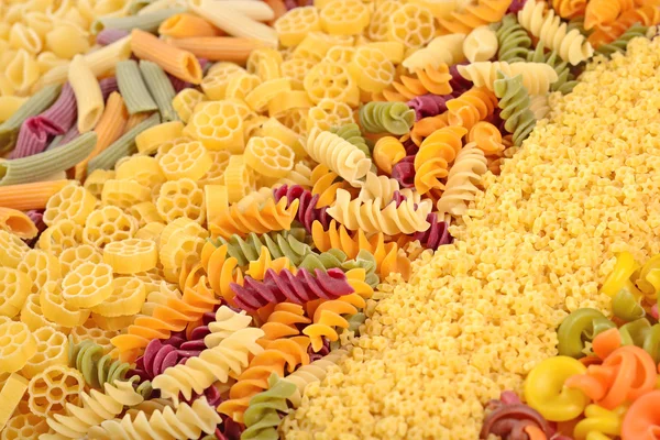 Assortment of colored uncooked Italian pasta close up