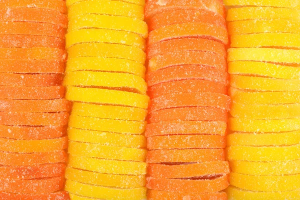 Orange and lemon candy slices as background