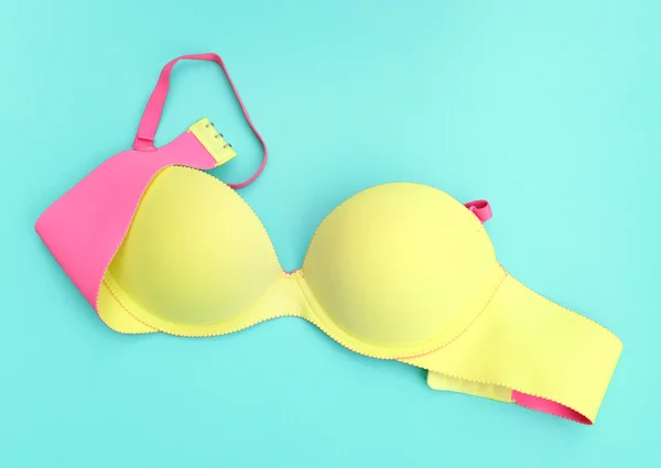 Summer concept, Yellow bra on blue background. (Pop art style)