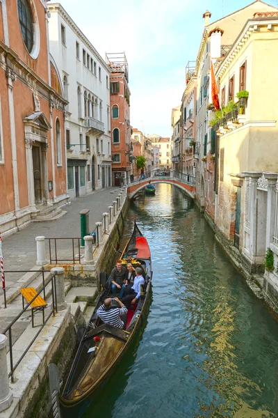VENICE, ITALY - APRIL 12, 2015: Tourists travel on gondolas in Venice, Italy . Gondola trips are the most popular tourist activity in Venice.