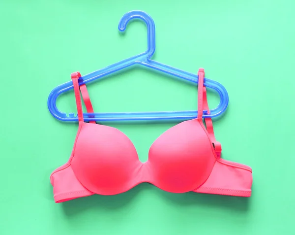Summer concept, bra on coat hanger on green. (Pop art style)