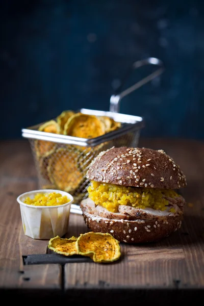 Gluten free Burger with sliced roast meat and cucumber relish, zucchini chips