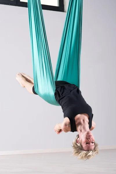 Female athlete doing aerial yoga arm stretches