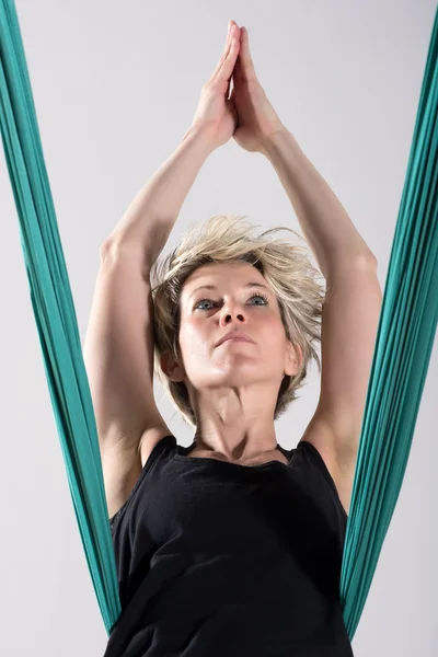 Single woman stretching with aerial yoga blanket