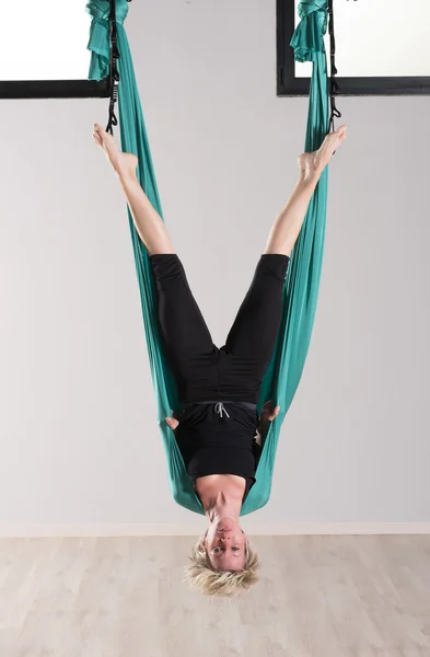 Upside down woman doing aerial yoga head stands