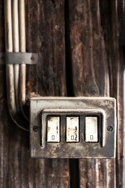 Row of three grungy electrical switches
