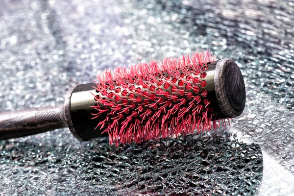 Red hairbrush on a textured table