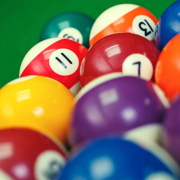 Billiard balls on a green pool table, closeup