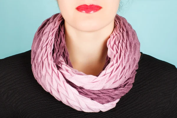 Silk scarf. Pink silk scarf around her neck isolated on blue background.