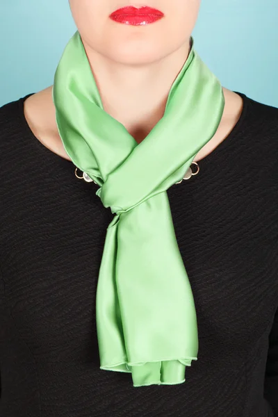 Silk scarf. Green silk scarf around her neck isolated on blue background.