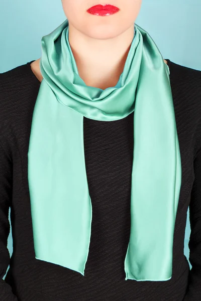 Silk scarf. Green silk scarf around her neck isolated on blue background.