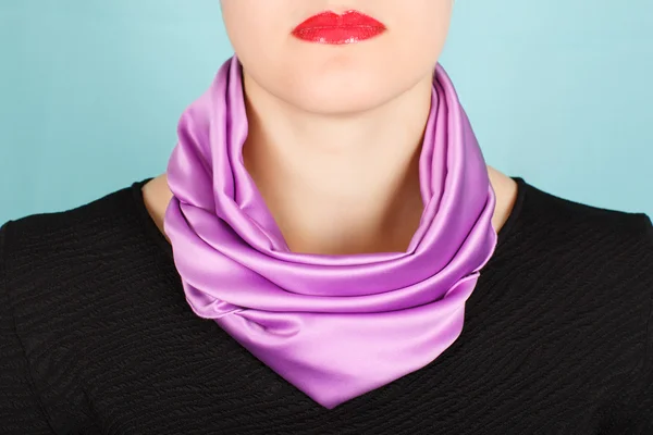 Silk scarf. Lilac silk scarf around her neck isolated on blue background.