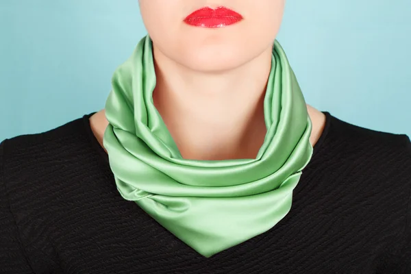 Silk scarf. Green silk scarf around her neck isolated on blue background.