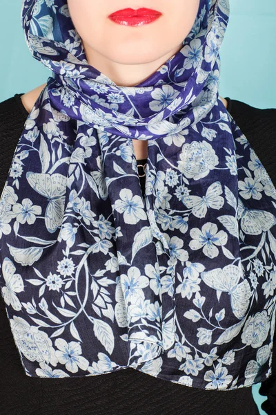 Silk scarf. Blue silk scarf around her neck isolated on blue background.