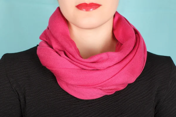 Silk scarf. Pink silk scarf around her neck isolated on blue background.