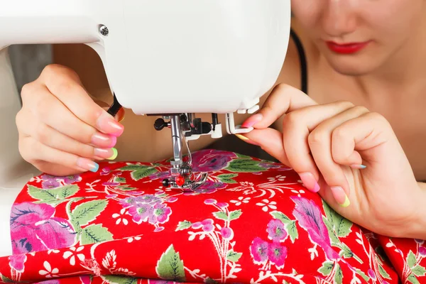Seamstress sew fabric on the sewing machine.