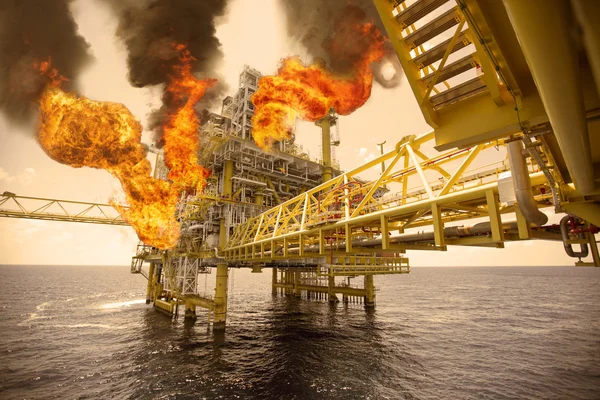 Offshore oil and gas fire case or emergency case in warm picture style, firefighter operation to control fire on oil and gas production platform, offshore worst case and can\'t control fire, man overboard.